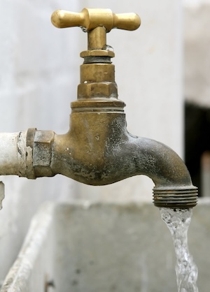 A garden tap with water flowing out.