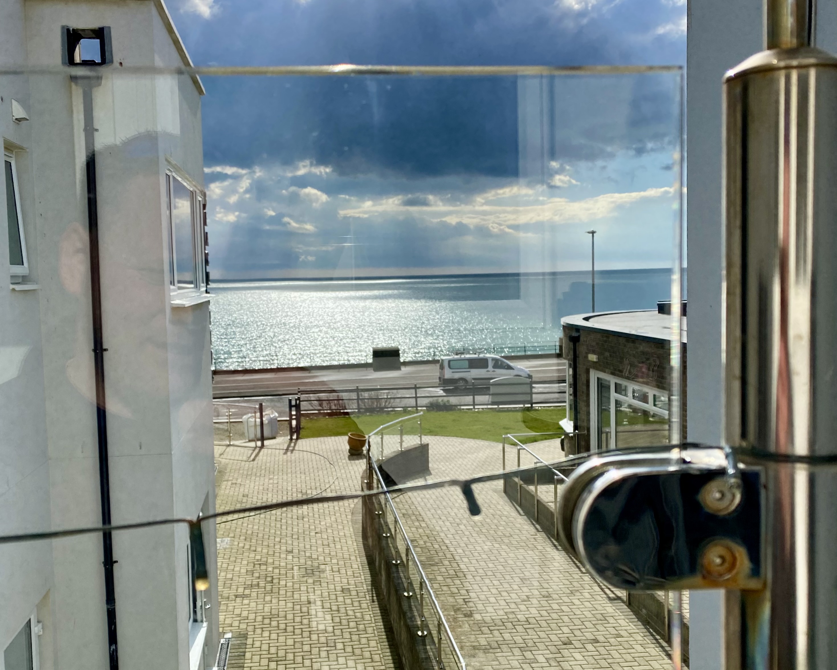 Looking through clean balcony windows facing the sea.