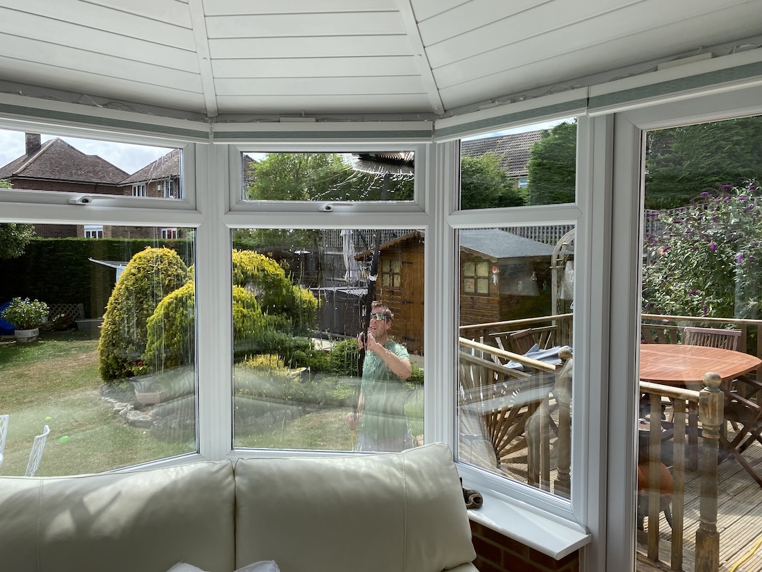 Windows of a conservatory being cleaned with pure water and brush.