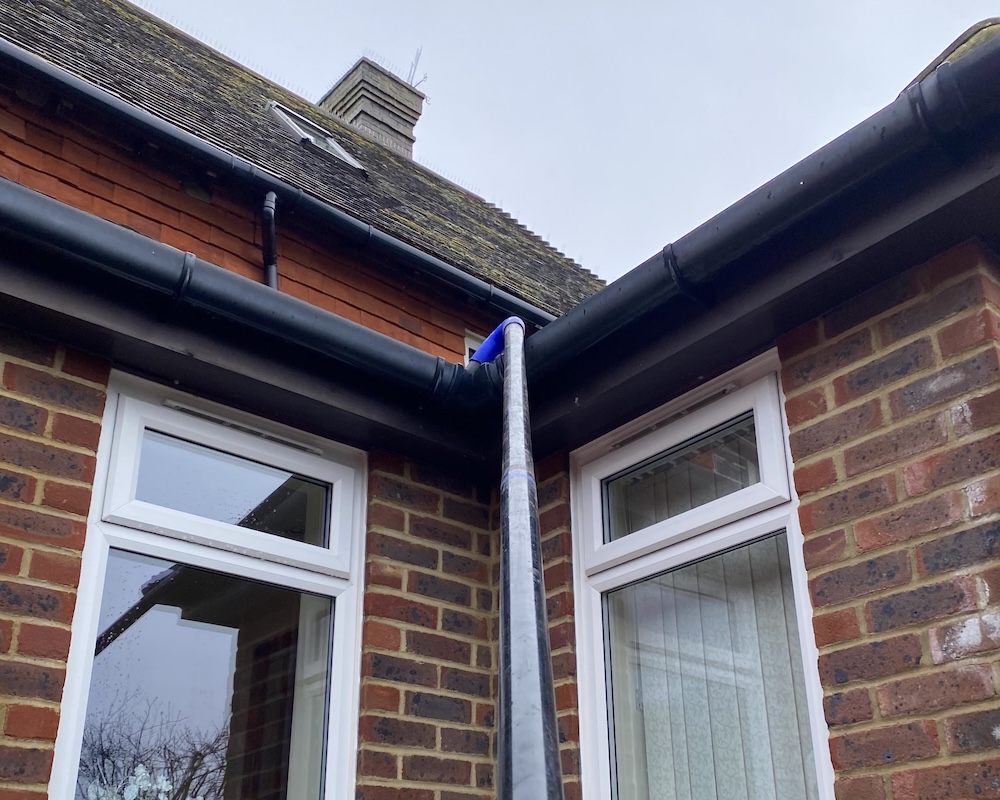 A pole reaching up to clean gutters.