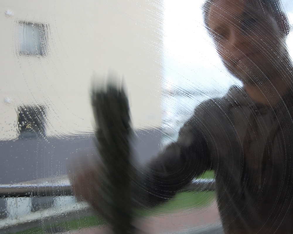 A man cleaning windows using traditional methods.