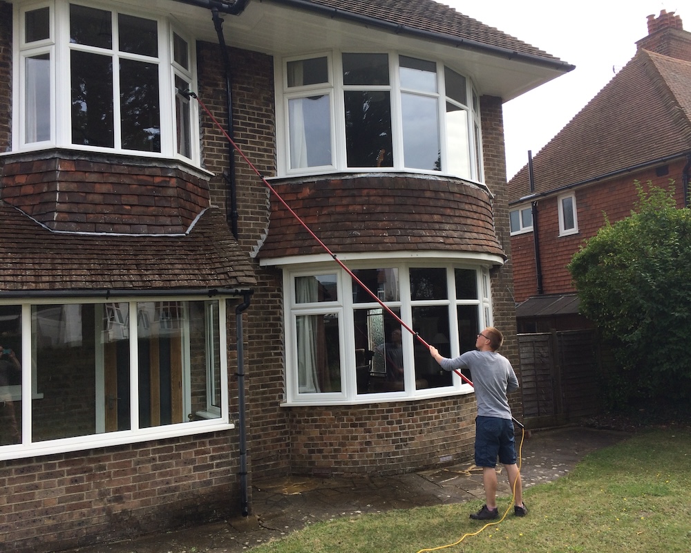 Windows on a house being cleaned with Reach and Wash system.